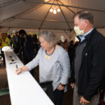 a person signs a steel beam for the student center at ϲʿֱֳ