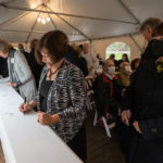 a person signs a steel beam for the student center at ϲʿֱֳ
