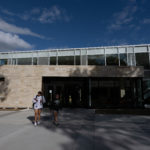 Two students walk outside the front of the Lowry Student Center at ϲʿֱֳ.