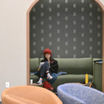 A student studying in the green theme room on the second floor of Lowry Center at ϲʿֱֳ.