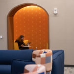 A student doing schoolwork in a yellow theme lounge on the second floor of Lowry Center at ϲʿֱֳ.